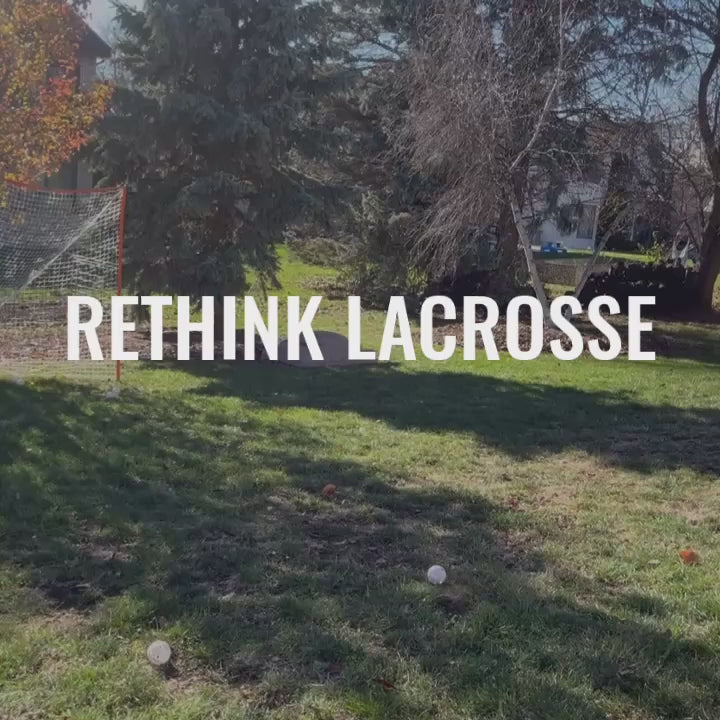 handsome man shoots wiffle balls with the people's lacrosse skill stick into a net in his backyard